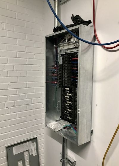 Open panelboard with breakers and branch wiring during installation